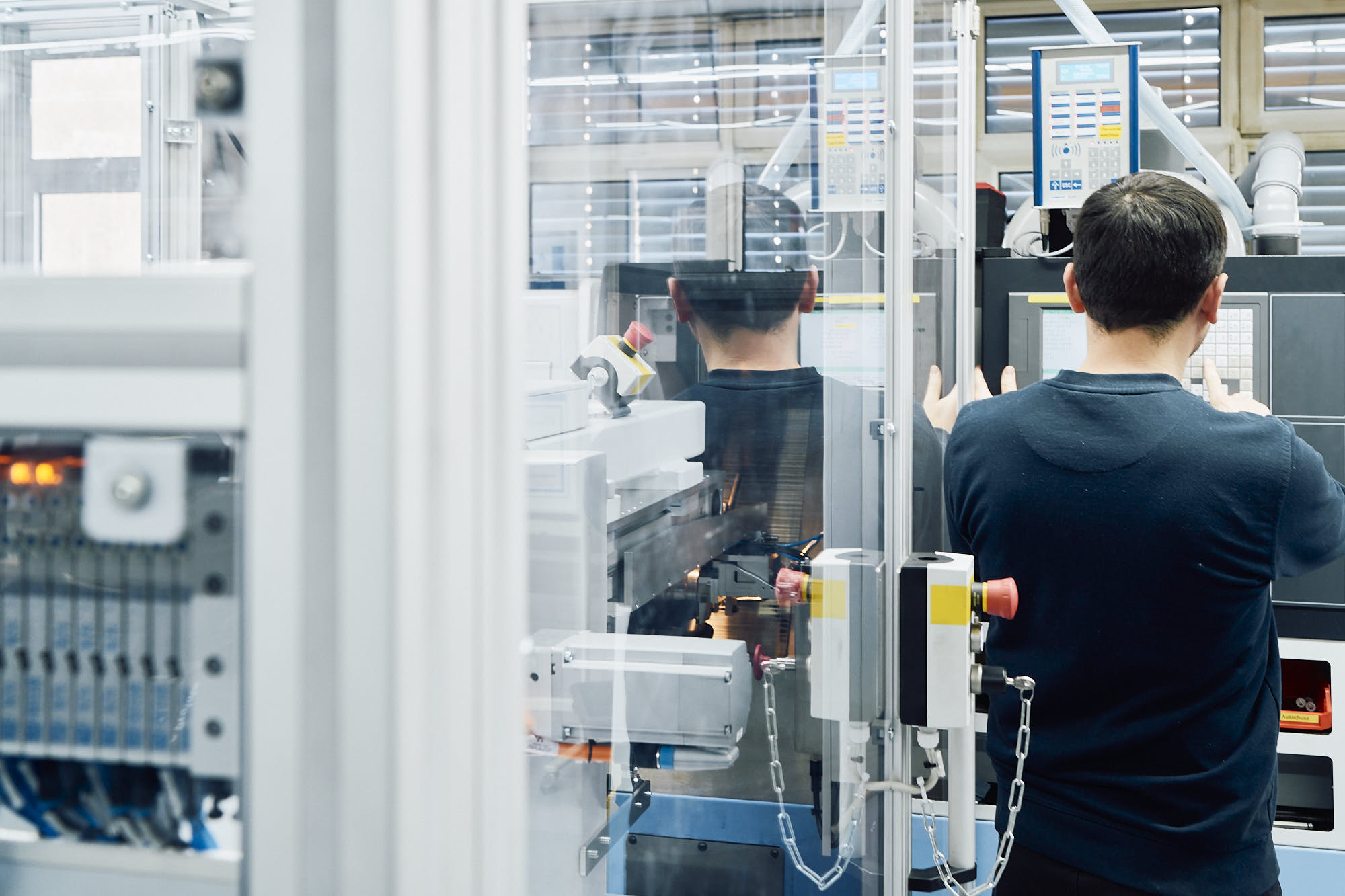 Mitarbeiter der Sauter GmbH richtet automatisierte Produktionsanlage ein.